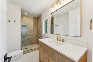 Bathroom featuring a tile shower, toilet, visible vents, recessed lighting, and vanity