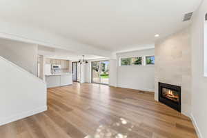 Unfurnished living room featuring light wood-type flooring, baseboards, visible vents, recessed lighting, and a tile fireplace