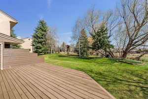 Wooden terrace featuring a yard