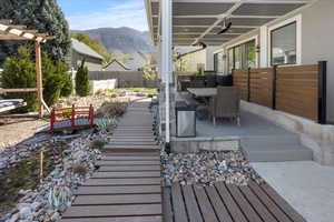 Wooden deck with a mountain view, fence, a patio area, and outdoor dining space