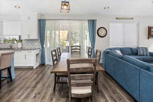 Dining space with dark wood-style floors and recessed lighting