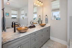 Primary Bathroom featuring tile patterned floors, a sink, and double vanity