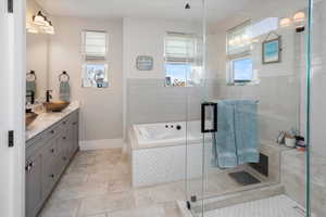 Primary Bathroom with a bath, a sink, double vanity, a stall shower, and tile patterned flooring