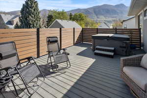 Balcony featuring a mountain view and a hot tub just off of the primary bedroom