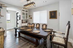 Formal Dining area featuring arched walkways, recessed lighting, and dark wood-style flooring