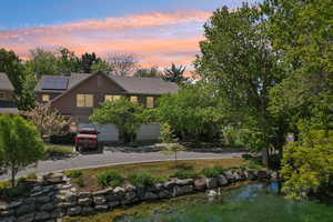 View of front of house with concrete driveway, a garage, a shingled roof