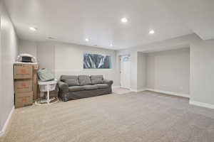 Carpeted living area with baseboards and recessed lighting