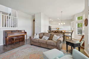 Living area with baseboards, recessed lighting, wood finished floors, and a chandelier