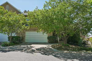 View of front of property with stucco siding, driveway, and stone siding