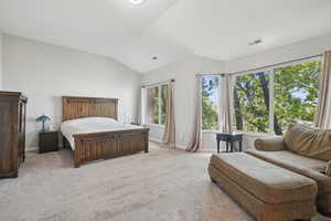 Bedroom featuring visible vents, baseboards, vaulted ceiling, and light carpet