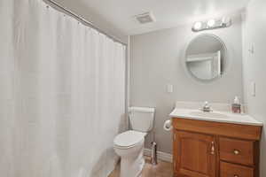 Bathroom with visible vents, tile patterned floors, baseboards, vanity, and toilet