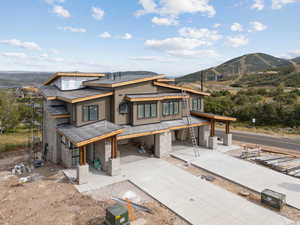 View of front of home with a mountain view and concrete driveway