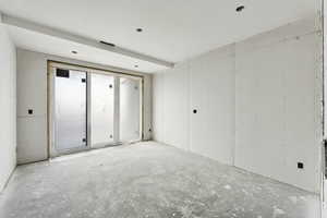 Unfurnished room featuring unfinished concrete floors