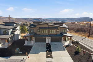 View of front of property featuring an attached garage, concrete driveway, and a mountain view