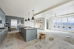 Kitchen with gray cabinets, stainless steel appliances, backsplash, a kitchen island, and recessed lighting