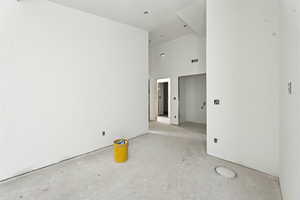 Unfurnished room featuring a towering ceiling