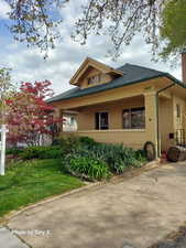 View of side of home featuring brick siding, a lawn, and a shingled roof