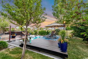 Wooden terrace featuring fence and a yard
