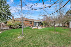 View of yard featuring fence and a patio
