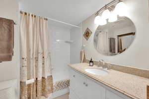 Bathroom featuring visible vents, shower / bath combo withshower curtain, and vanity