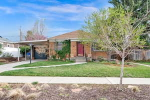 View of front of home featuring brick siding, driveway, and an attached carport