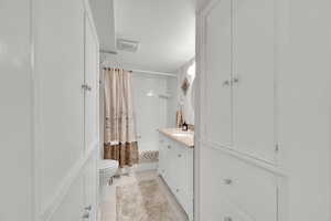 Full bathroom featuring visible vents, toilet, tile patternedfloors, vanity, and shower / bath combination with curtain
