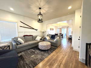 Living room with wood finished floors, a chandelier, and recessed lighting