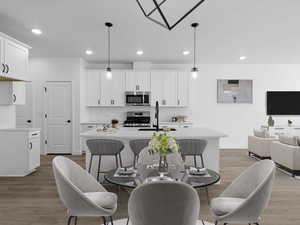 Kitchen with an island with sink, appliances with stainless steel finishes, a sink, and light countertops