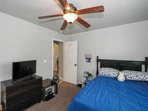 Carpeted bedroom featuring baseboards and ceiling fan