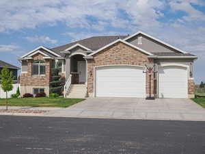 View of front of home featuring stucco siding, driveway, a front yard, and a garage