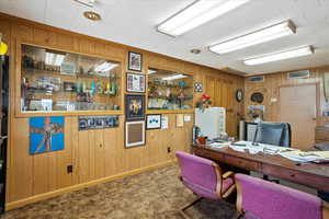 Carpeted office with visible vents and wood walls