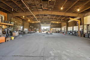 Miscellaneous room with vaulted ceiling and concrete flooring