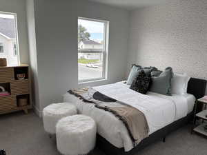 Bedroom with wallpapered walls and carpet flooring