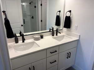 Bathroom with a shower stall, a sink, and double vanity