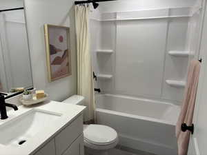 Bathroom featuring shower / bath combo, vanity, and toilet
