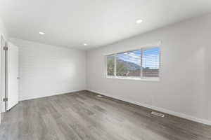 Spare room with baseboards, wood finished floors, visible vents, and recessed lighting
