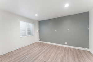 Unfurnished room with light wood-style flooring, baseboards, and recessed lighting