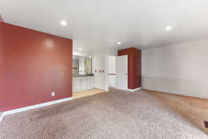Interior space with light carpet, baseboards, and recessed lighting