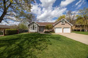 Single story home with fence, a front lawn, an attached garage, driveway, and brick siding