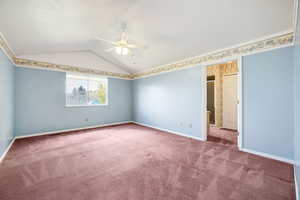 Carpeted spare room featuring lofted ceiling, baseboards, and ceiling fan