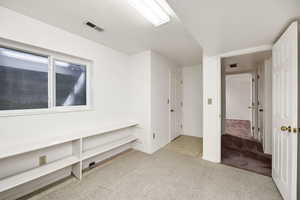 Carpeted empty room featuring baseboards and visible vents