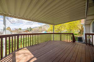Deck with a lawn, a mountain view, central AC, and a playground