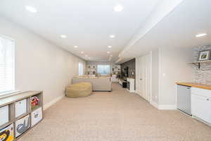 Open basement with built-in dry bar, open shelving and bench.
