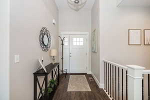Foyer entrance featuring baseboards and dark wood-type tile flooring