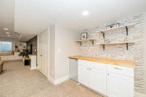 Bar featuring light colored carpet, baseboards, recessed lighting, and fridge