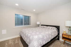 Basement bedroom featuring baseboards, visible vents, recessed lighting, and carpet flooring