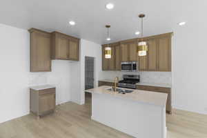 Kitchen with light wood-style flooring, appliances with stainless steel finishes, and decorative backsplash
