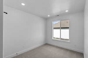 Unfurnished room featuring light colored carpet, baseboards, visible vents, and recessed lighting
