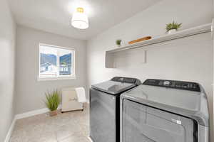 Washroom with baseboards, a textured ceiling, laundry area, and independent washer and dryer