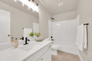 Second Floor Full bathroom with tile floors, vanity with black and brass details, and bathtub / shower combination